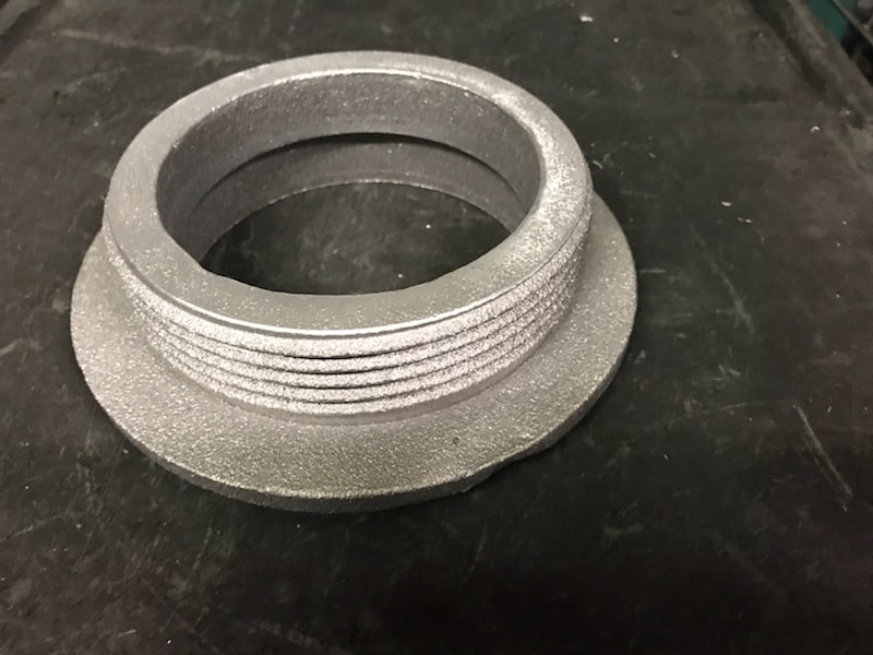 Example aluminum fuel bung component showing as cast threads.